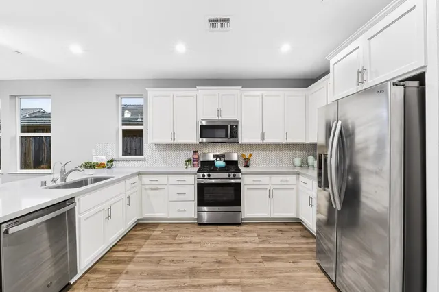a kitchen with stainless steel appliances a refrigerator and cabinets
