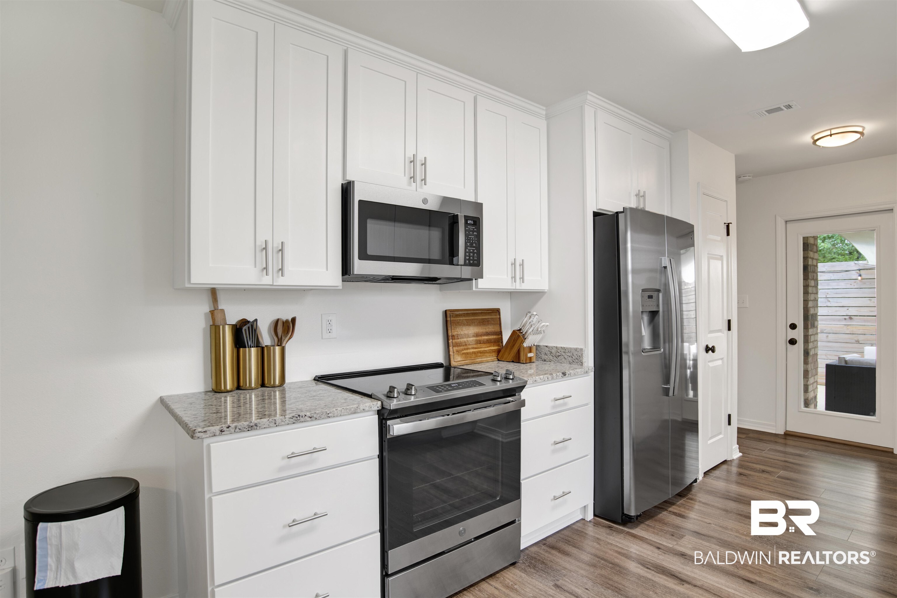 4012 Kendallbrook Loop Foley, AL 36535 - Photo 11 of 31 Kitchen with stainless steel appliances, white cabinetry, light wood-style flooring, and light stone countertops