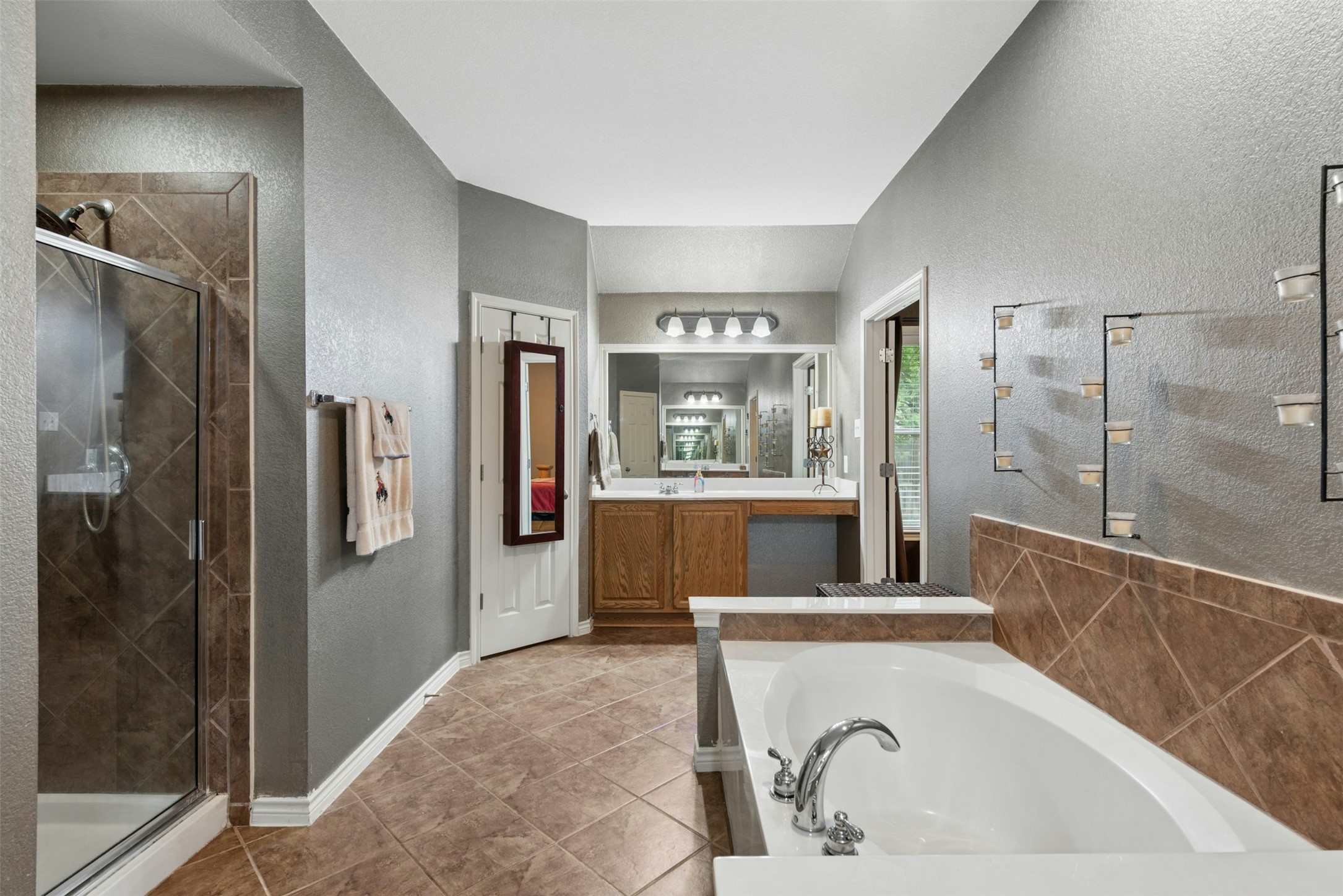 30013 Edgewood Drive Georgetown, TX 78628 - Photo 19 of 39 The bathroom features a soaking bathtub, a walk-in shower with a glass enclosure with seat, and two separate vanities