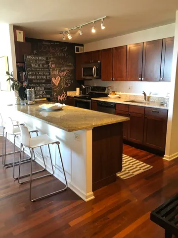 a kitchen with stainless steel appliances granite countertop a stove a sink and a microwave