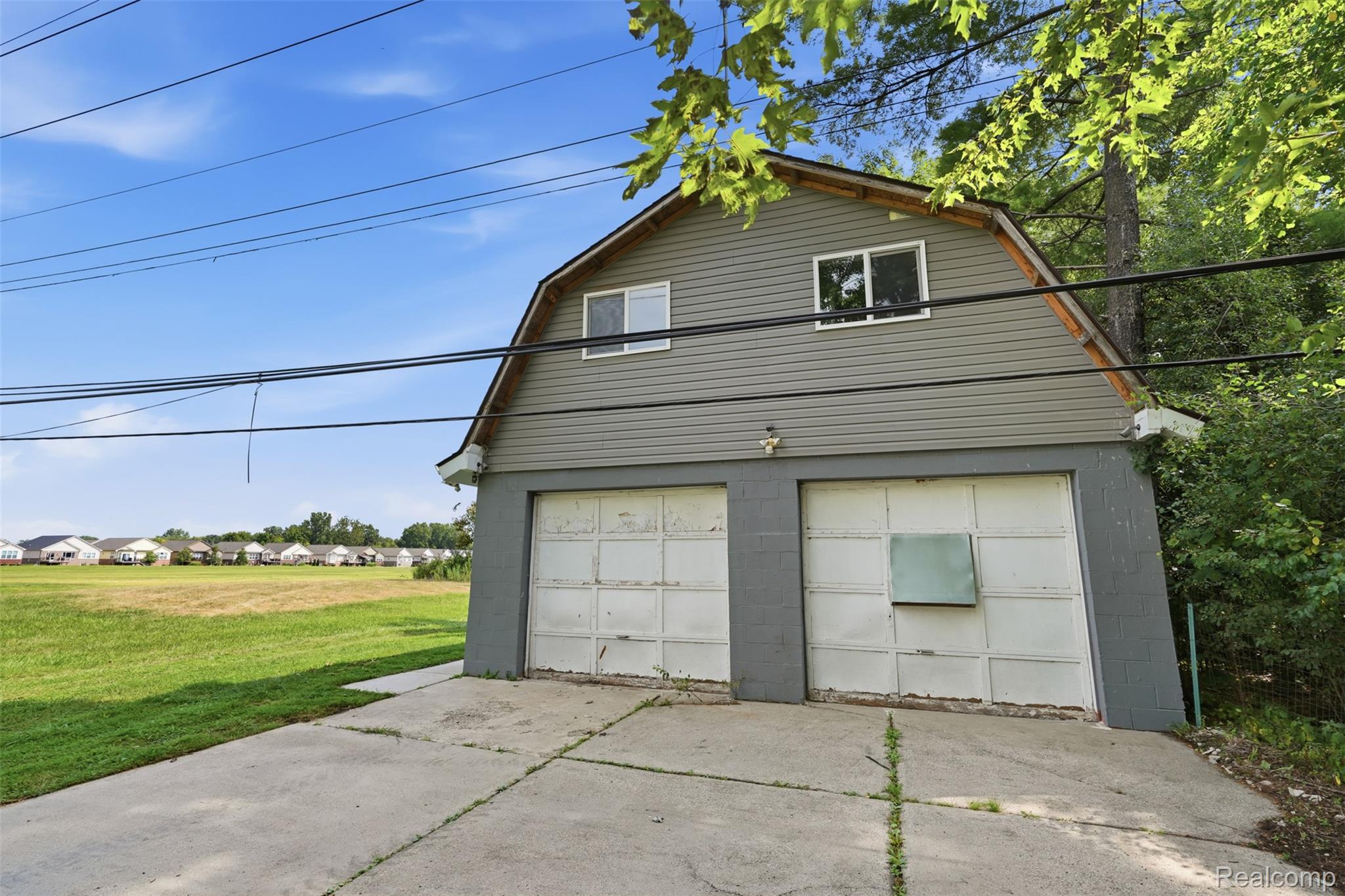 4655 Denton Road Canton, MI 48188 - Photo 41 of 54 Two-car garage with overhead doors and a second-story dormer