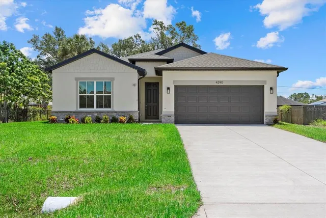 a front view of a house with a garden and plants