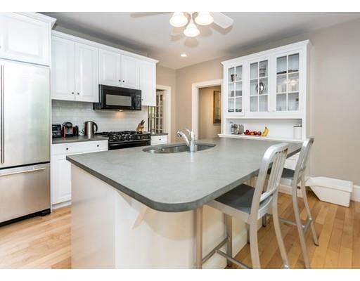 19 Forest Street Newton, MA 02461 - Photo 16 of 33 a kitchen with stainless steel appliances kitchen island granite countertop a dining table chairs and refrigerator