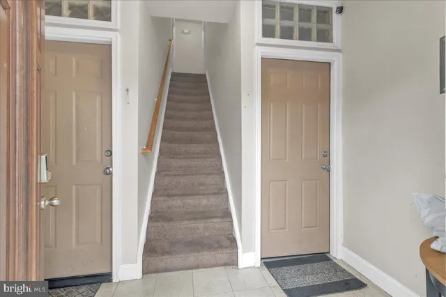 a view of a hallway with a door and stairs