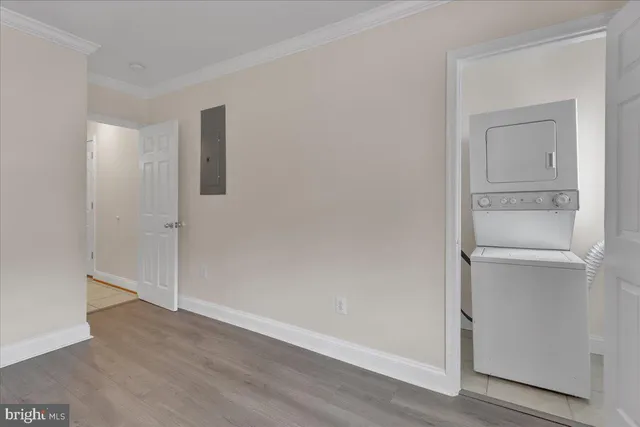a view of an empty room with wooden floor and closet