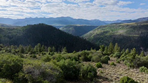 a view of a lush green hillside and a building in the background