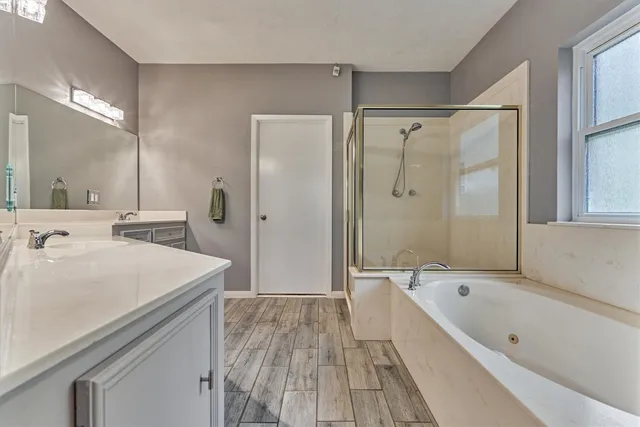 a bathroom with a tub a sink shower and mirror