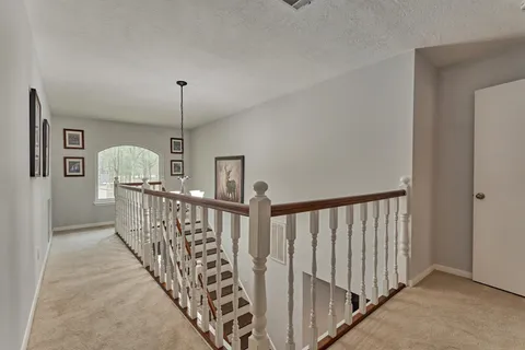 a view of staircase with railing and white walls