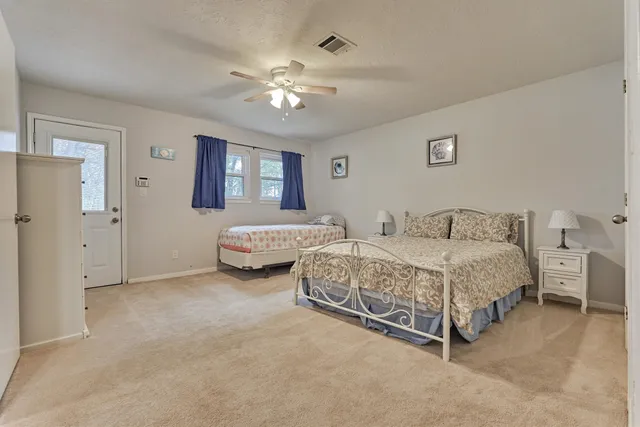 a spacious bedroom with a bed and a chandelier
