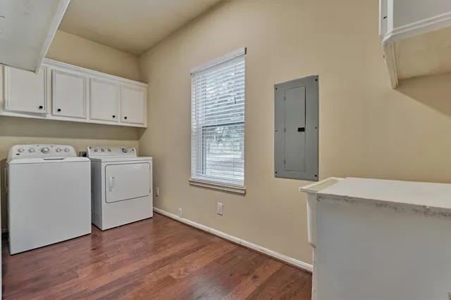 a view of a kitchen with wooden floor and electronic appliances