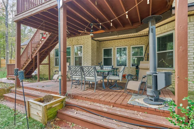 a view of a patio with table and chairs potted plants and floor to ceiling window and potted plants