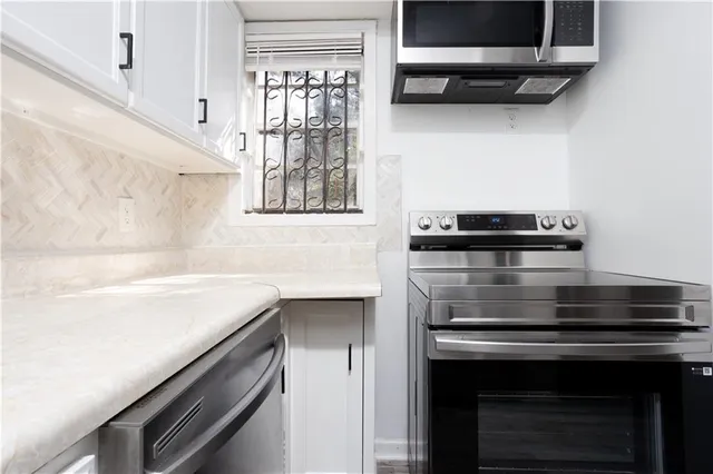 a kitchen with stainless steel appliances a stove and a microwave