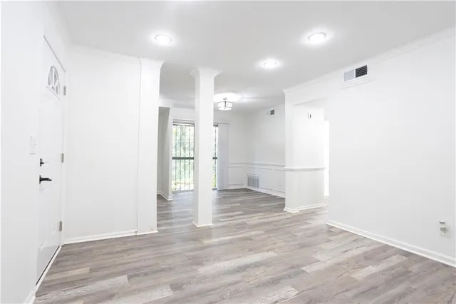 a view of empty room with wooden floor