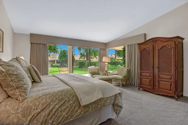 a bed sitting in a spacious bedroom next to a window