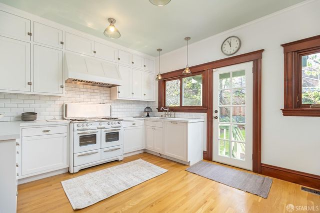 a kitchen with a stove a sink and a window