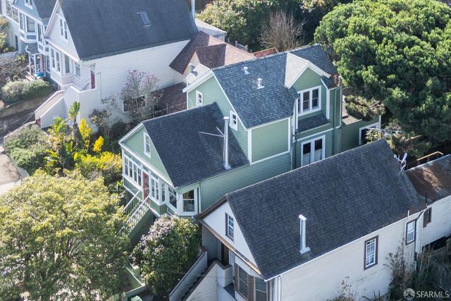 a aerial view of a house with a yard and large tree