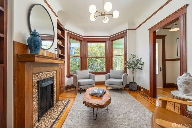 a living room with furniture a fireplace and a large window