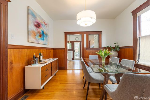 a view of a dining room with furniture a chandelier and wooden floor