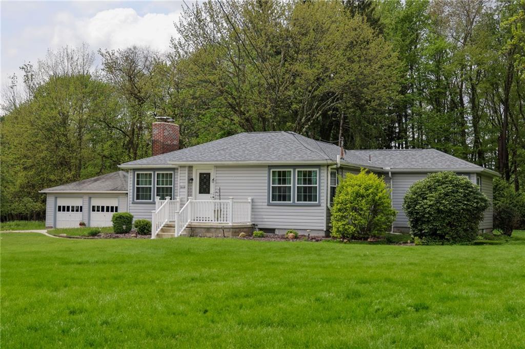a front view of a house with a yard and trees