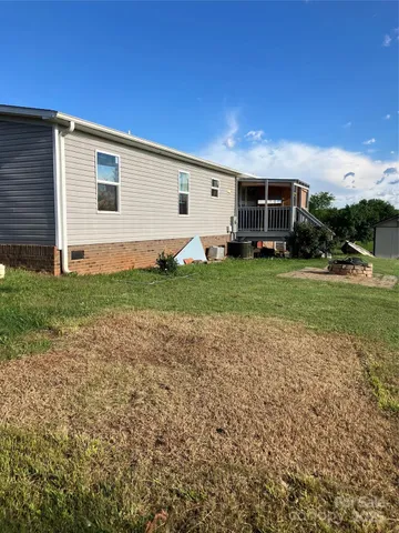 a view of a backyard with plants and large tree