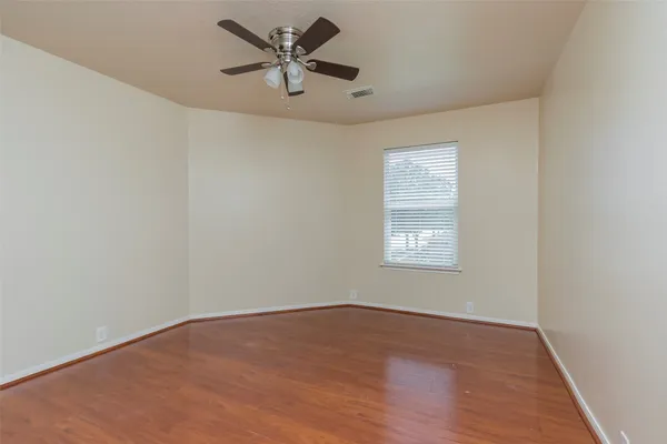 an empty room with a window and a ceiling fan