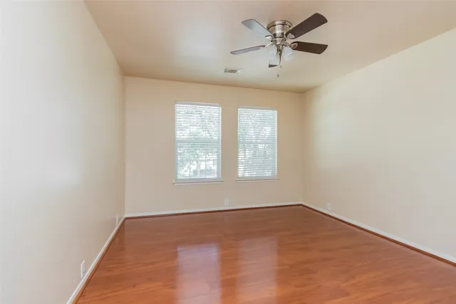 an empty room with a window and a ceiling fan
