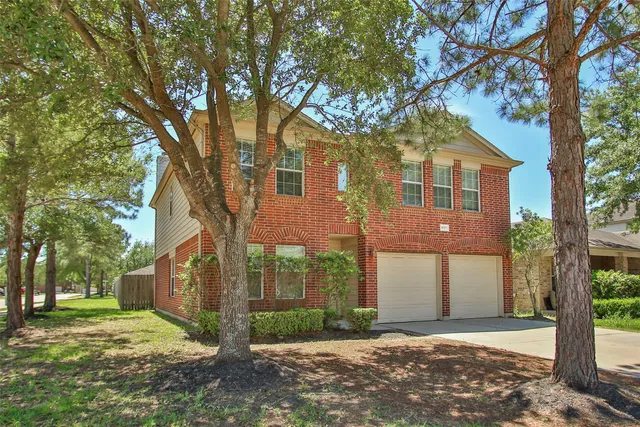 a front view of a house with a yard and large trees