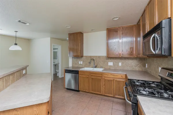 a kitchen with stainless steel appliances a sink stove and cabinets