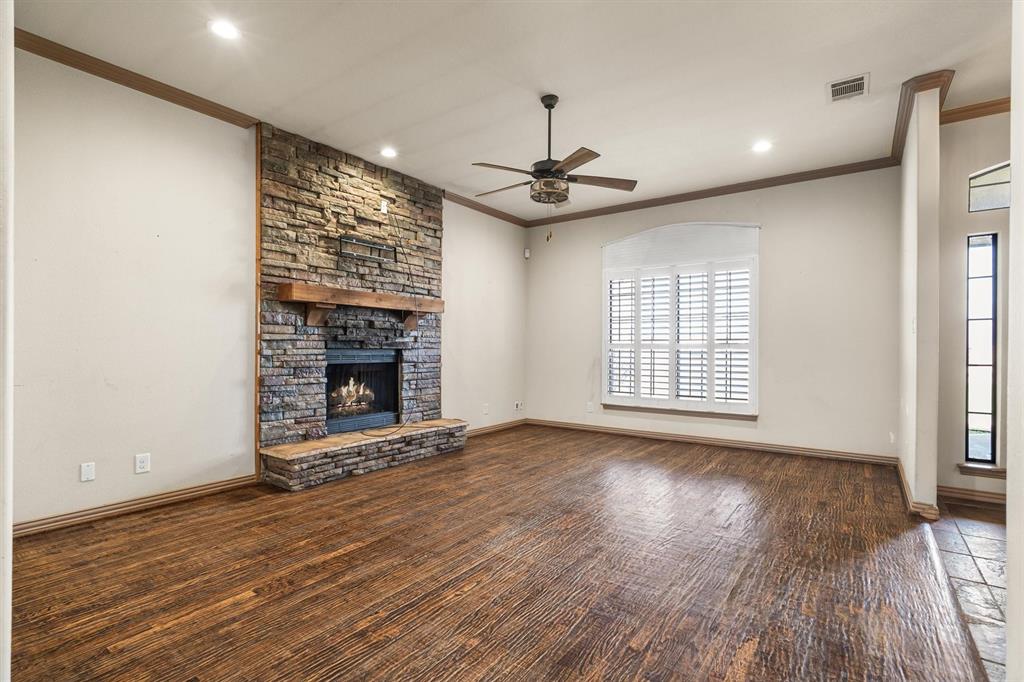 6210 Deer Run Road Sanger, TX 76266 - Photo 14 of 40 a view of an empty room with wooden floor fireplace and a window