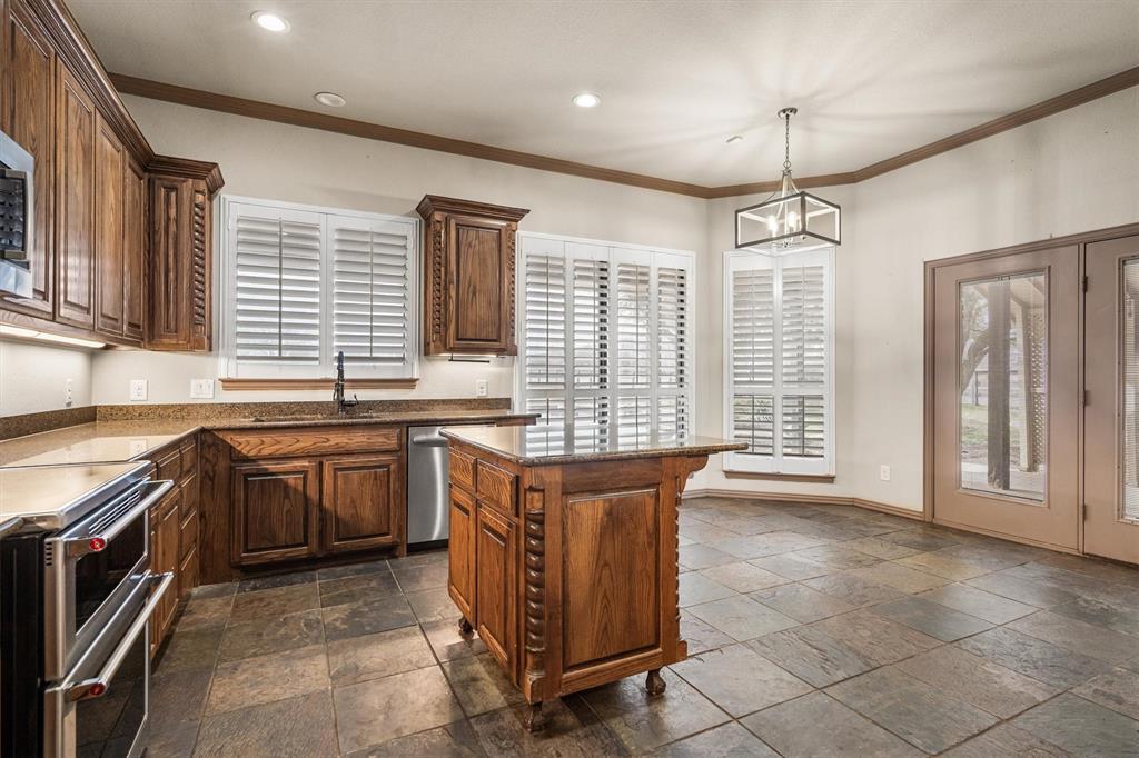 6210 Deer Run Road Sanger, TX 76266 - Photo 17 of 40 a kitchen with granite countertop a sink stove and cabinets