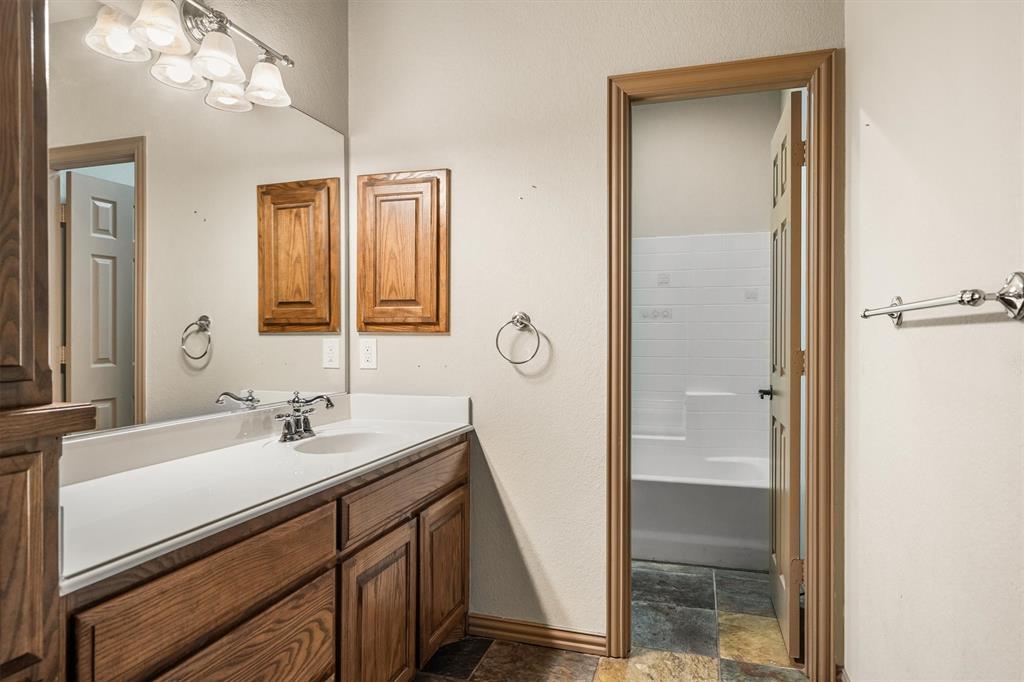 6210 Deer Run Road Sanger, TX 76266 - Photo 24 of 40 a bathroom with a sink a vanity and a mirror