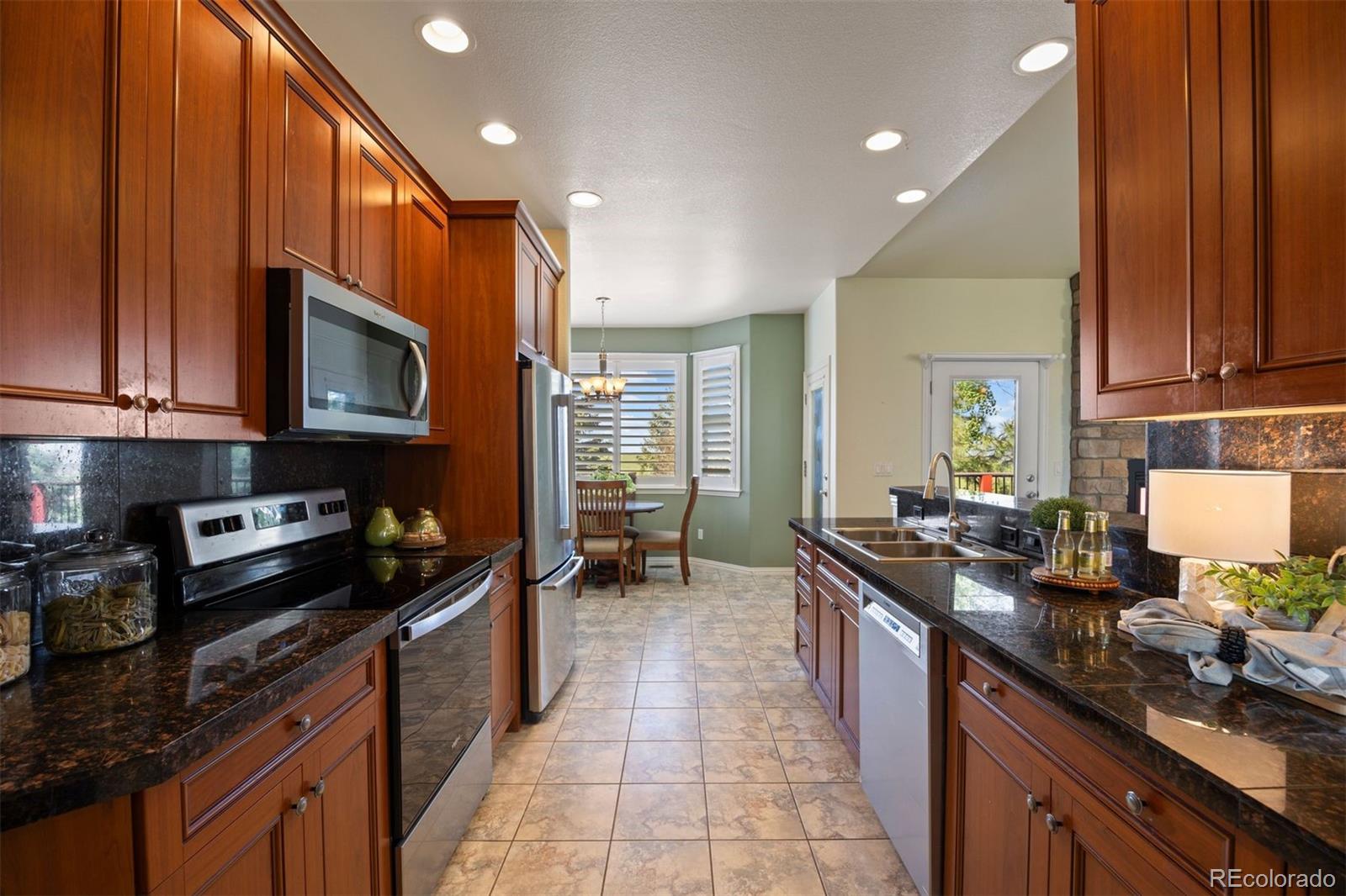 3519 Zane Grey Loop Parker, CO 80138 - Photo 18 of 40 a kitchen with granite countertop a sink stove and cabinets