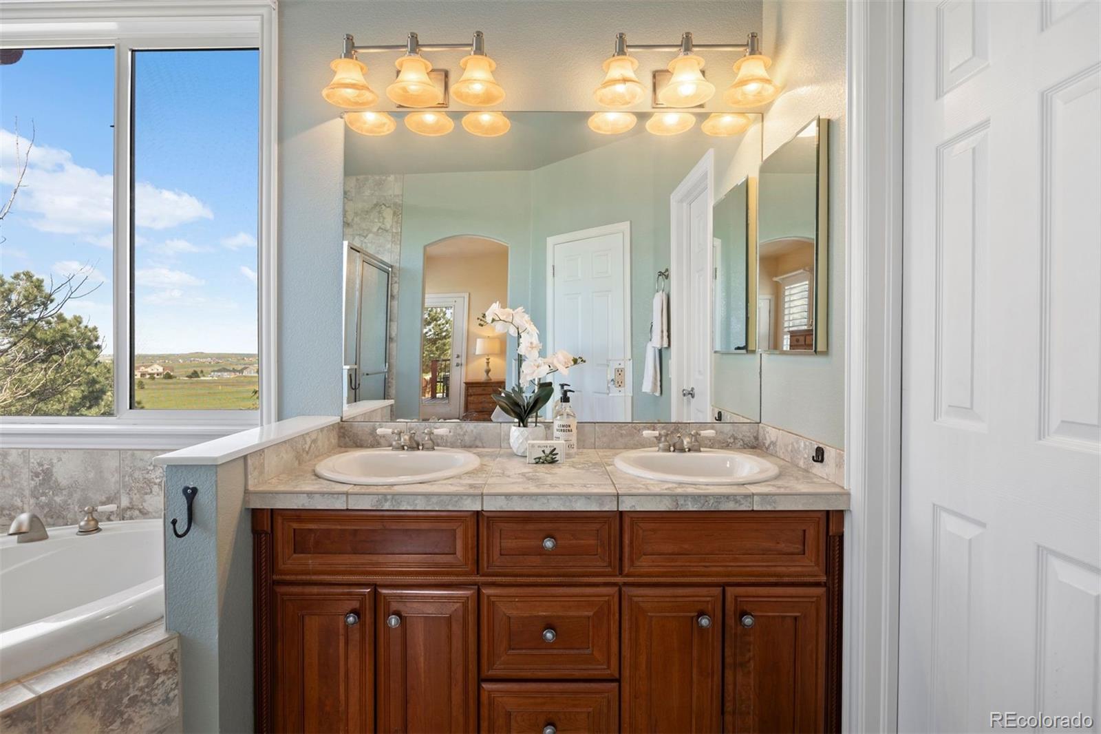 3519 Zane Grey Loop Parker, CO 80138 - Photo 29 of 40 a bathroom with a double vanity sink and a mirror