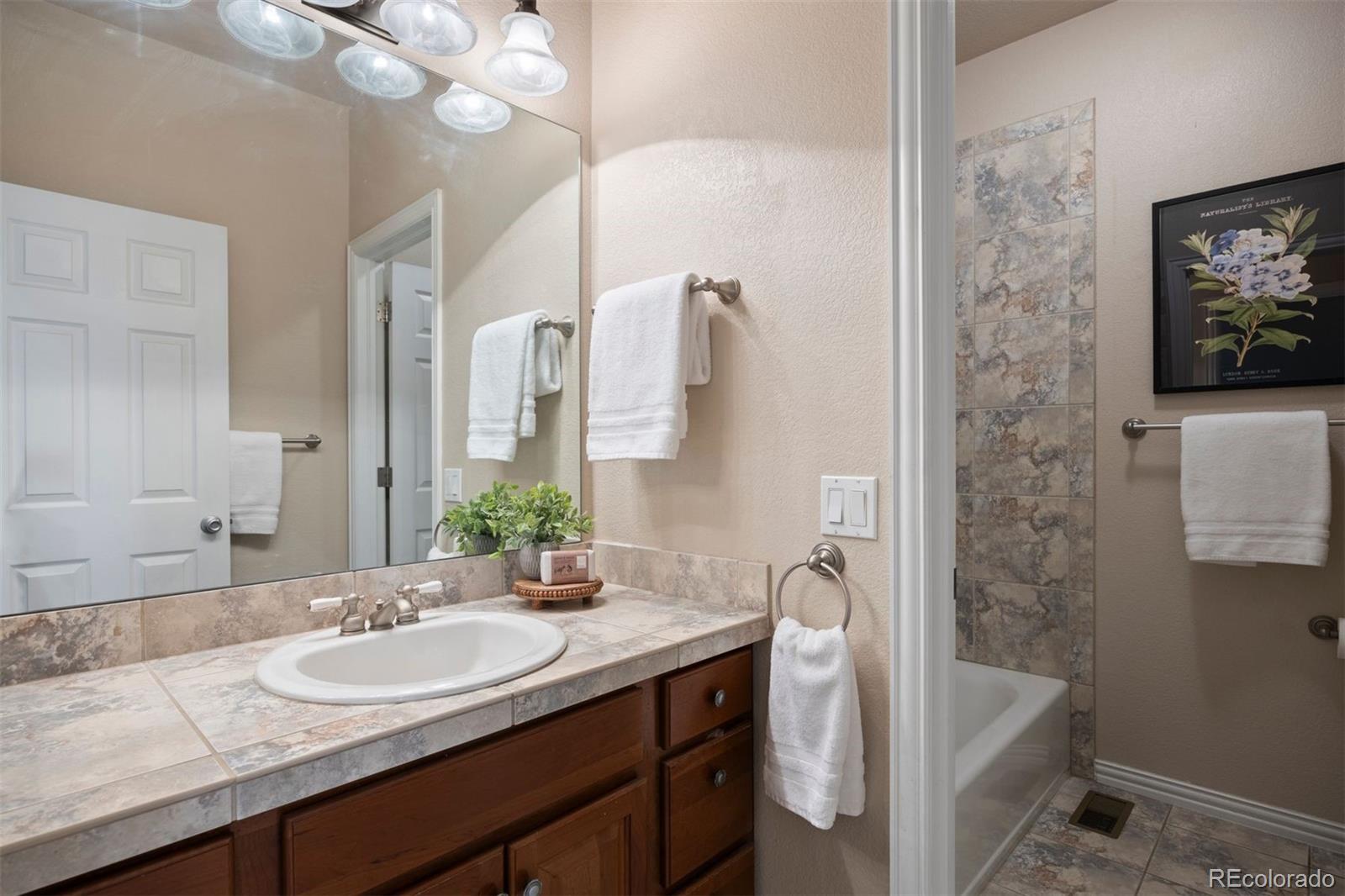 3519 Zane Grey Loop Parker, CO 80138 - Photo 34 of 40 a bathroom with a granite countertop sink a toilet and a mirror