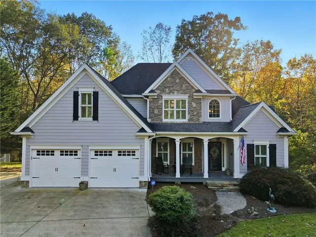 a view of a yard in front of a house with plants and large tree