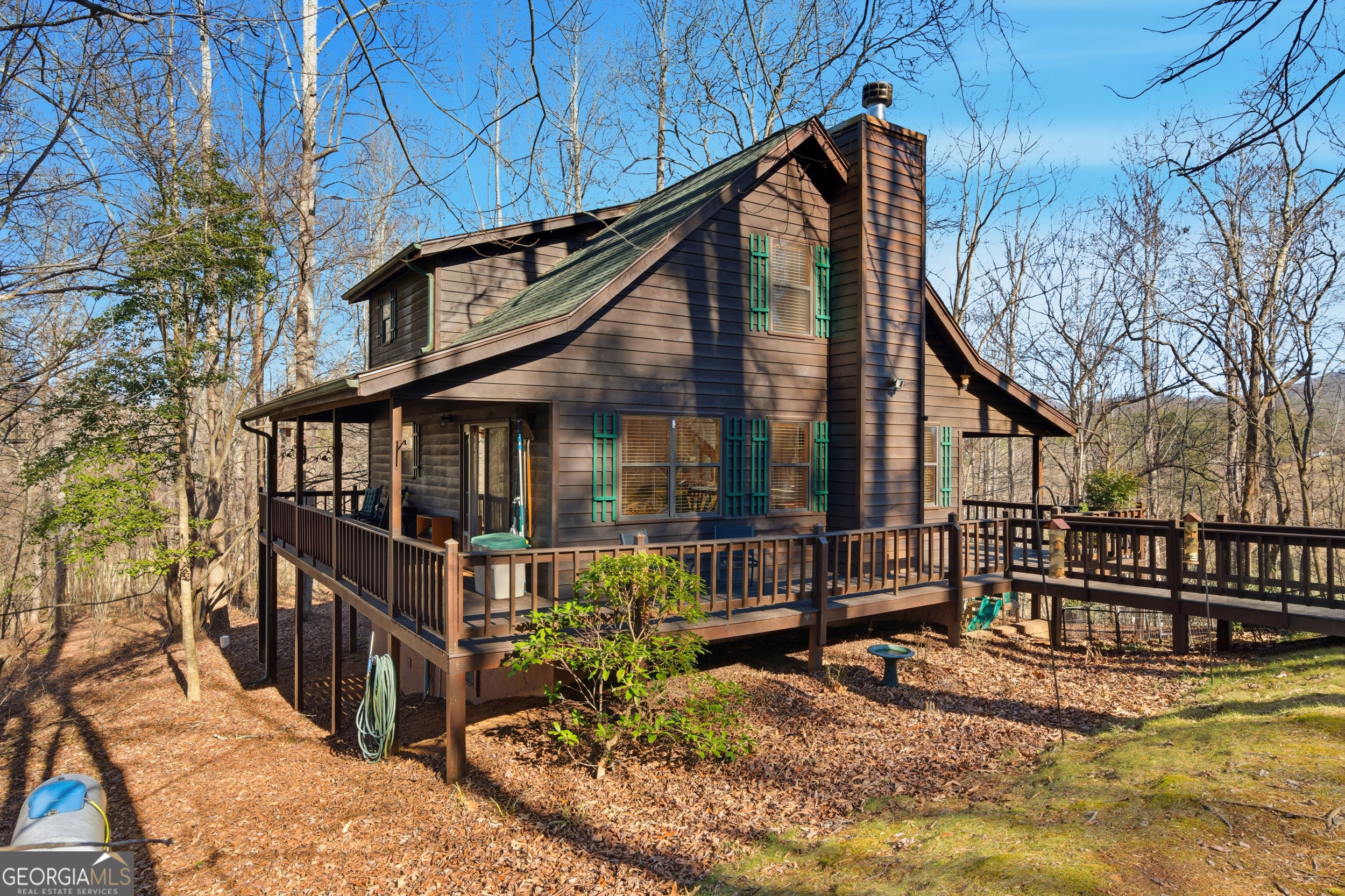a view of a house with large wooden stairs and a small yard