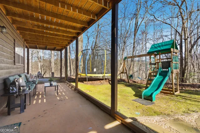 a view of swimming pool with lawn chairs and wooden fence