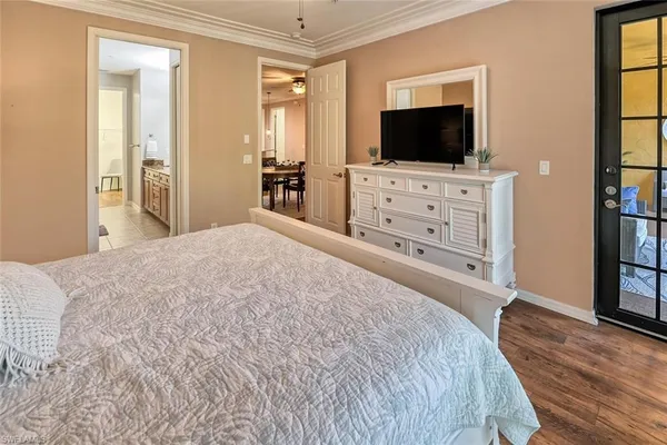 a spacious bedroom with a bed and a flat screen tv