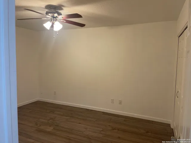 a view of an empty room with wooden floor