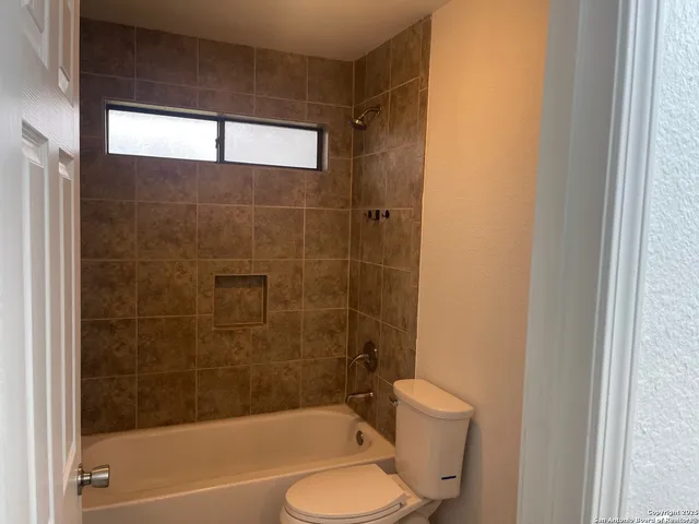 a bathroom with a bathtub shower sink vanity and toilet