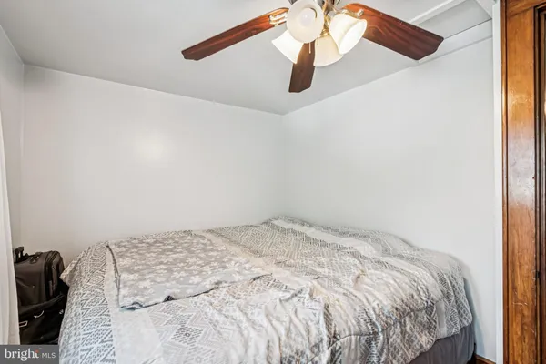 a bedroom with a bed and a ceiling fan