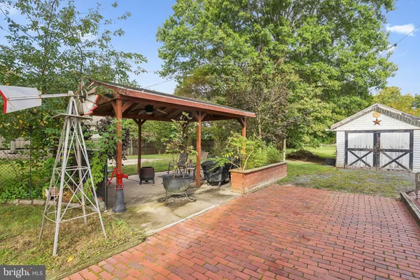 a view of a patio with table and chairs potted plants and large tree