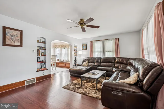 a living room with furniture ceiling fan and a window