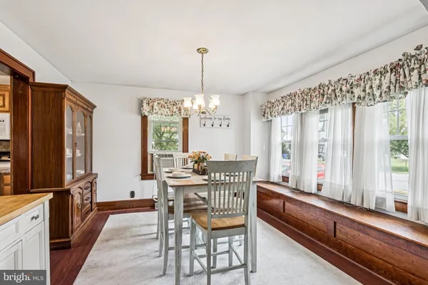 a dining room with furniture a chandelier and window