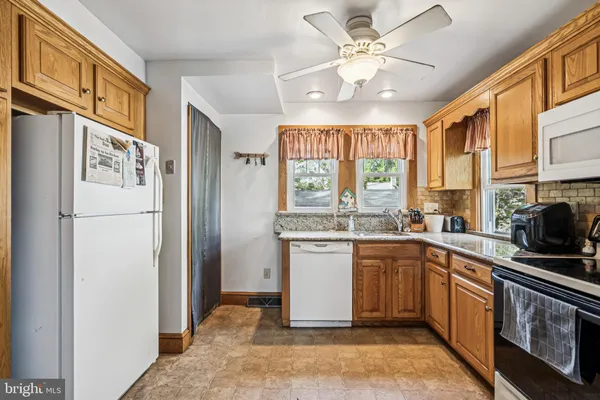 a kitchen with a refrigerator a stove a sink and cabinets