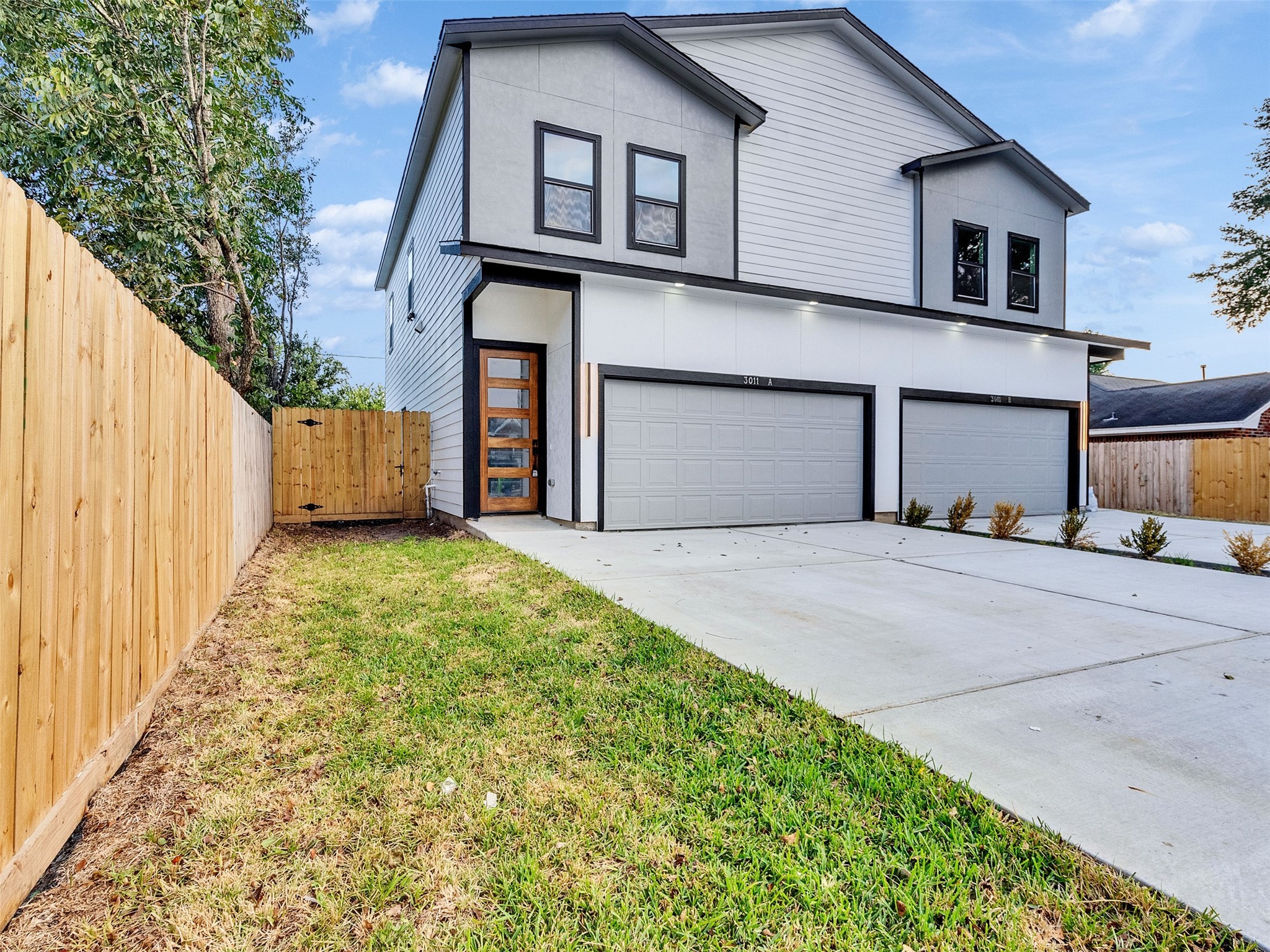 6014 Grace Lane, Unit A/B Houston, TX 77021 - Photo 2 of 36 a front view of a house with a yard and garage