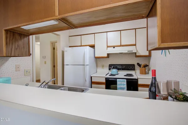 a kitchen with stainless steel appliances a refrigerator and a stove top oven