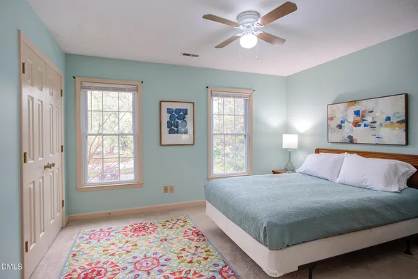 a bedroom with a bed and a painting on the wall