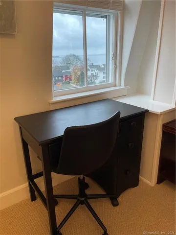 a black leather chair sitting in a kitchen next to a window