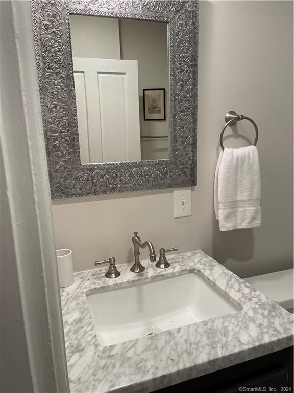 51 Front Street Groton, CT 06340 - Photo 14 of 21 a bathroom with a granite countertop sink and a mirror
